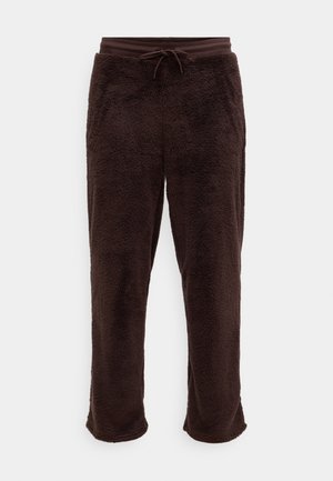 Braune Fleece-Jogginghose mit weicher Textur, ausgestattet mit einem elastischen Bund und einer verstellbaren Kordel. Der Saum hat eine leichte Ausbuchtung.