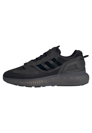 Sort Adidas sneaker med mesh og syntetisk overdel, tyk sål, tre sorte striber på siden og mærket hælkappe trækkrog.