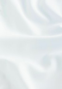 Material de satin alb cu o textură netedă și strălucitoare, căzând elegant în pliuri delicate. Nu există modele sau detalii suplimentare.