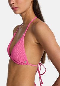 Top bikini lavorato a maglia rosa con coppe a triangolo, dotato di spalline sottili e chiusura a fiocco sul retro; tessuto texturizzato e dettaglio rotondo con logo.
