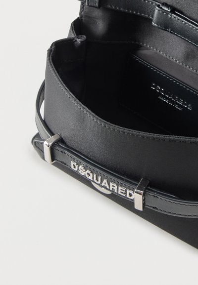 Sac à main noir Dsquared2 avec ouverture sur le dessus, bandoulière en cuir et détail du nom de la marque en argent sur le bord avant.