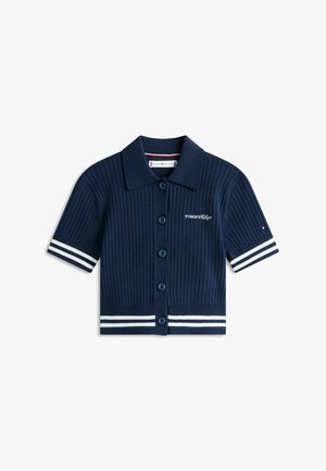 Tengerészkék bordázott rövid ujjú póló gombos elejjel, fehér csíkozással az ujjakon és az alján, a mellrészen hímezett logóval.