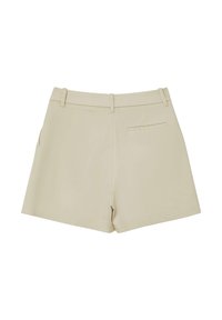Shorts taillés beiges à taille haute, avec poches avant et une poche arrière. Fabriqués dans un tissu lisse avec une texture nette.