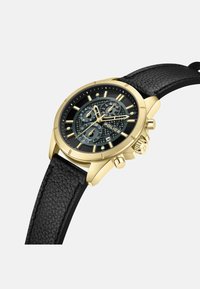 Orologio cronografo dorato con cinturino in pelle nera texturizzata, dotato di un quadrante nero con dettagli argentati e tre sottodial.