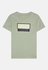 Camiseta de algodón verde claro con mangas cortas. Presenta un gráfico rectangular con el texto "JACK&JONES" en negro y amarillo en la parte frontal.