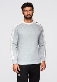 Sudadera gris con mangas raglán blancas, con cuello redondo, puños de canalé y un detalle de logo en el hombro izquierdo. Textura suave.