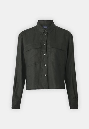 Fekete, rövidített, hosszúujjú lenvászon ing, hegyes gallérral, gombos elülső résszel és két mellzsebbel. Simább textúrájú, laza kialakítású.