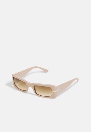 Square-framed sunglasses in matte beige with gradient brown lenses, featuring a small white logo detail on the side.