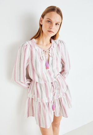Stripet kjole i hvit, rosa og svart med lange ermer, knytehals og volangkant. Har en dekorativ frynse i lilla.