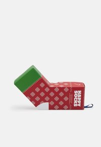Balení ve tvaru ponožek v červené a zelené barvě s geometrickým vzorem, modrá visačka a nápis "HAPPY SOCKS" vytištěný na boku.