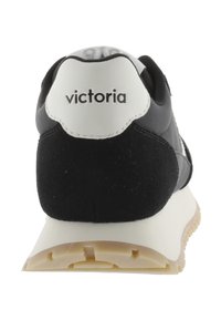 Baskets noires avec un talon en daim texturé, un accent blanc à l'arrière et une semelle en caoutchouc beige. "Victoria" imprimé en noir sur le talon.