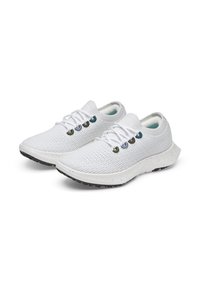 Des chaussures de sport blanches avec un dessus en maille texturée, dotées d'œillets colorés, d'une semelle blanche rembourrée et d'une semelle extérieure en caoutchouc noir offrant une bonne traction.