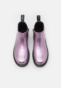 Metalliska lila ankelstövlar med en slät textur, elastiska sidopaneler, svarta gummisulor och dragflikar för enkel på- och avtagning.