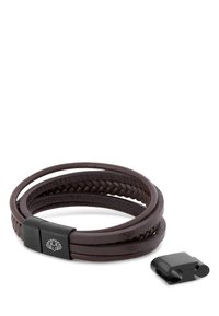Brown leather braided bracelet with a flat clasp featuring a lotus flower design, accompanied by a separate black hardware piece.