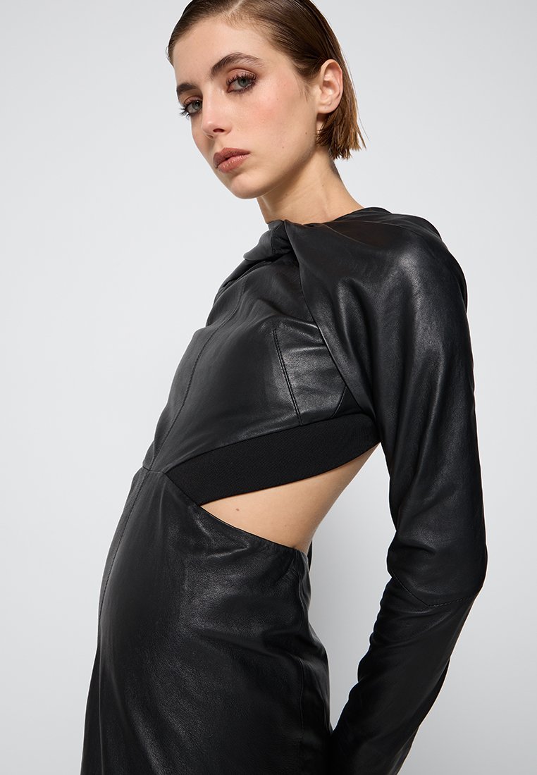 Czarna skórzana sukienka o dopasowanym kroju, z długimi rękawami i wycięciami po bokach. Gładka tekstura i unikalny kaptur.