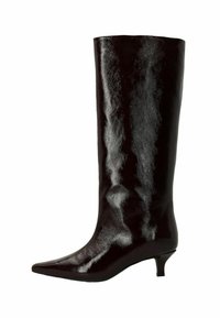 Botte noire en cuir verni, montant jusqu'au genou, avec un bout pointu et un petit talon kitten, présentée de côté sur un fond blanc.