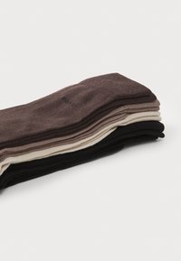 Set of socks in shades of brown, beige, and black, made from textured fabric; design features a simple, seamless shape with minimal branding.