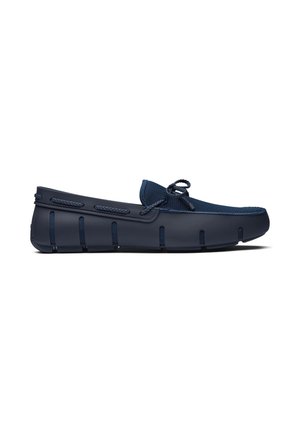 Marineblauwe instap loafer met mesh bovenwerk, gevlochten veterdetail en rubberen zool met verticale groeven voor grip en flexibiliteit.