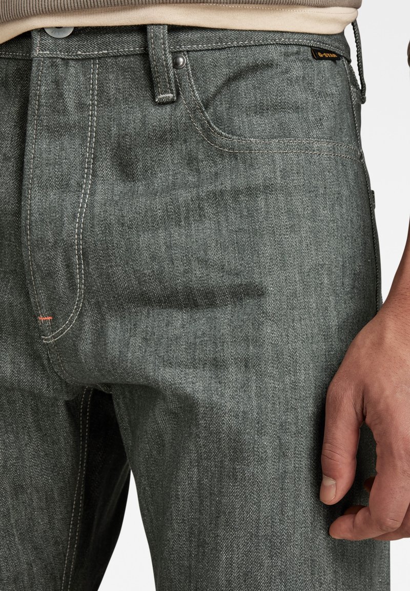 Grijze denim jeans met een rechte snit, voorzien van een klassieke vijf-pocket ontwerp, subtiele stiksels en een opvallend merklabel op de tailleband.