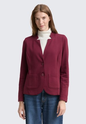 Burgundy blejzr s na míru navrženým střihem, dvěma předními kapsami a dvěma knoflíky. Pruhová textura a lehký materiál, vrstvený přes bílý rolák.