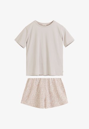 Jasnobeżowy t-shirt z krótkim rękawem w połączeniu z jasnoróżowymi szortami z elastycznym pasem w panterkę na białym tle.