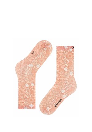 Skarpety w kolorze brzoskwiniowym z białymi kwiatowymi i falistymi wzorami, z czarną nazwą marki "Burlington" w pobliżu palców.