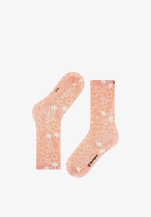 Pfirsichfarbene Socken mit weißen Blumen- und wellenförmigen Mustern, mit dem Markennamen „Burlington“ in Schwarz nahe den Zehen.