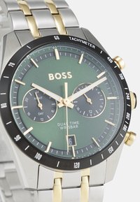 Orologio da polso cronografo con quadrante verde, cassa in acciaio inossidabile dorato e argentato, lunetta nera, due sottocifre e una finestra della data alle 6.