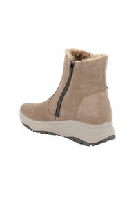 Stivaletto beige con finitura in suède, fodera in pelliccia sintetica, cerniera laterale e suola chunky grigia testurizzata.