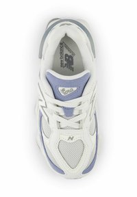 Scarpa da corsa bianca e lilla chiaro con materiali in rete e scamosciato, forma arrotondata, dettagli testurizzati e design con lacci. Presenta il logo 'N'.