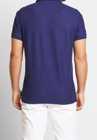 Polo shirt bleu marine en coton, avec un col classique et des manches courtes, au toucher doux et à la coupe ajustée.