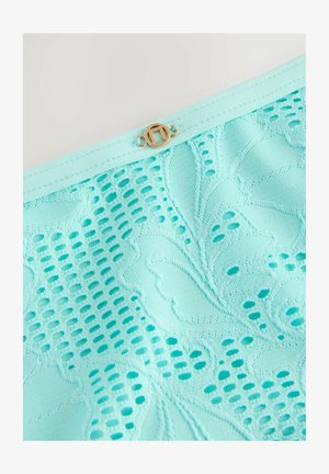 O țesătură din dantelă verde menta cu modele florale intricate și un mic clasp auriu în partea de sus. Textura este ușoară și transparentă.