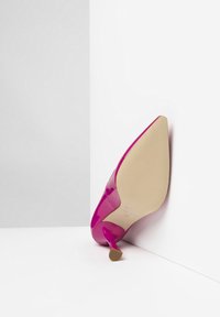 Chaussure à talons hauts en cuir verni rose avec un bout pointu et un talon aiguille mince. Présente une semelle beige avec un motif texturé.
