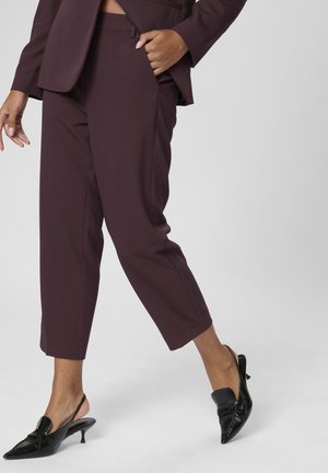 Burgundy tailored trousers with a slim fit and cropped length, paired with black pointed-toe slingback heels featuring a bow accent.