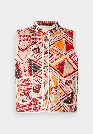 Gilet multicolore avec des motifs géométriques en rouge, orange, rose et noir, avec une bordure beige et des poches avant. Fermeture à boutons.