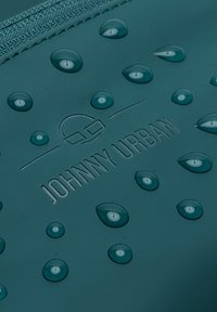 Teal vattentätt material med vattendroppar och präglad "JOHNNY URBAN" logotyp, med en minimalistisk design och slät textur.