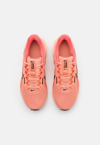 Nike Laufschuhe in leuchtendem Korallenrot mit einem strukturierten Mesh-Obermaterial, schwarzen Akzenten und einer gepolsterten Sohle. Mit Schnürsenkeln und gepolstertem Schaft.