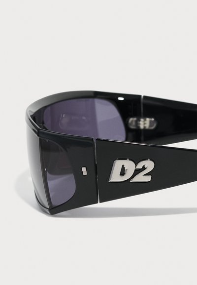 Ochelari de soare negri cu lentile întunecate, rame unghiulare și un logo metalic „D2” pe lateral. Finisaj neted cu accente lucioase.