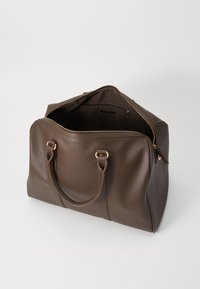 Brown leather duffel bag with gold-toned hardware, zip closure, and two sturdy handles. Spacious interior with a pocket for small items.
