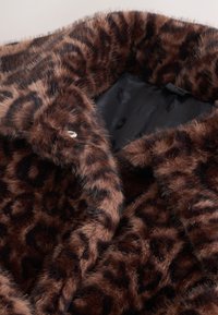 Cappotto morbido in pelliccia sintetica marrone con motivo leopardato scuro e fodera interna in raso nero.