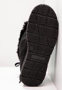 Černá bota s texturovanou gumovou podrážkou, vybavená huňatým podšívkou pod límcem a šněrovacím designem. Velikost 37 je vyražena na podrážce.
