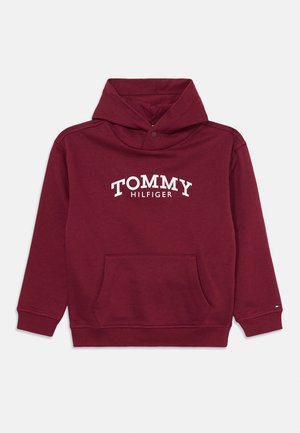 Bordeauxfarbener Hoodie aus weichem Material, mit einer Vordertasche, Kordelzugkapuze und einem weißen "TOMMY HILFIGER"-Logo über der Brust.