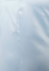 Tecido azul claro com uma textura suave, apresentando um leve brilho e padrões de vincos diagonais, indicando um design suave e fluido.