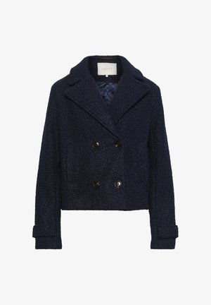 Veste bleu marine croisée en tissu texturé, dotée de grands boutons, de grands revers et d'un design court.