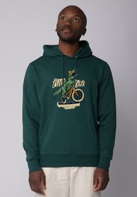 Groene hoodie met een voorzak en een grafisch ontwerp van een dinosaurus op een fiets, met de tekst "Ride Bike" in crème- en oranjeaccenten.