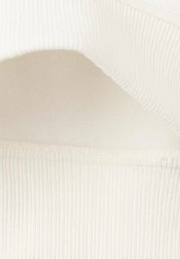 Vitt ribbat tyg med en slät textur och en lätt glans. Kanterna är fint sydda och visar en subtil, mjuk kurvatur.