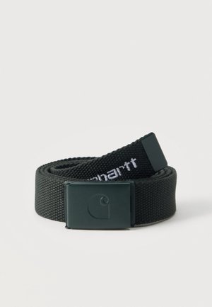Ceinture en tissu noir tissé roulée avec une boucle en métal noir mat présentant un logo embossé simple et un texte de marque brodé en blanc.