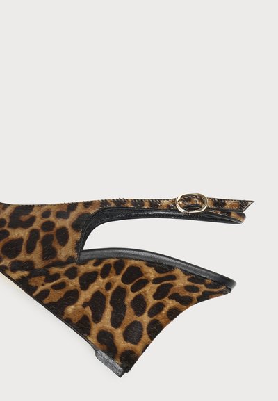 Escarpin à talon haut imprimé léopard marron et noir avec bride à boucle dorée, présenté sur fond blanc uni.