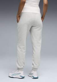 Γκρι φόρμες με ελαστικά μανίκια, πλαϊνές τσέπες και απαλό υλικό, σε συνδυασμό με λευκά αθλητικά παπούτσια με γαλάζιες λεπτομέρειες.