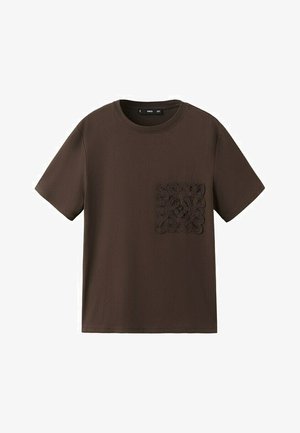 T-shirt marron à manches courtes avec col rond et une poche carrée en dentelle détaillée sur la poitrine gauche.